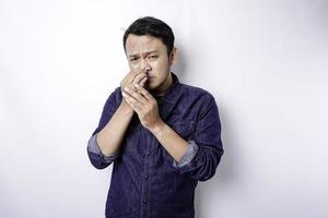 A portrait of an Asian man wearing a blue shirt isolated by white background looks depressed photo