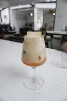 A glass of Iced coffee latte with strawberry syrup and topped with crackers or biscuits photo