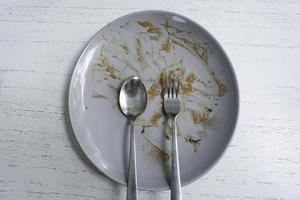 Top view of dirty dishes with sauce smeared on a plate isolated on white background photo