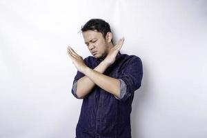 Handsome Asian man wearing blue shirt with hand gesture pose rejection or prohibition with copy space photo