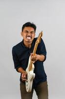 Portrait of Young Asian man in blue shirt with electronic guitar isolated on white background photo