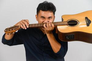 Portrait of Young Asian man playing an acoustic guitar isolated on white background photo