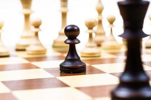 atacando al peón negro y la reina contra el ajedrez blanco foto