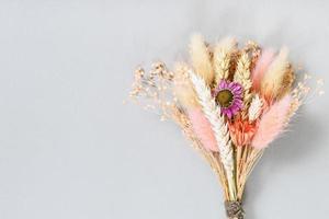 tied bouquet of dried flower and spikelets on gray photo