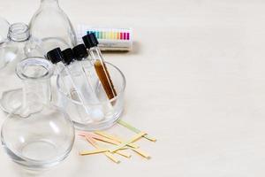 test tubes with various liquids, flasks on table photo