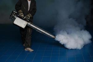 Man spraying fogging, eliminating mosquitoes, stopping the spread of dengue fever photo