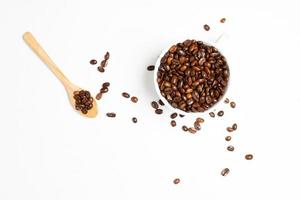 A cup of coffee and roasted coffee beans on white wood background
