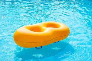 Yellow rubber ring floating in the pool photo