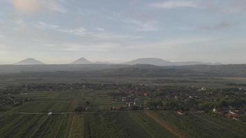 montaña aérea en indonesia cerca del pueblo con fondo de amanecer video