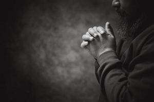Hands folded in prayer on in church concept for faith, spirituality and religion, man praying in the morning. man hand with praying god. Person Christian men who have faith in Jesus worship in dark. photo