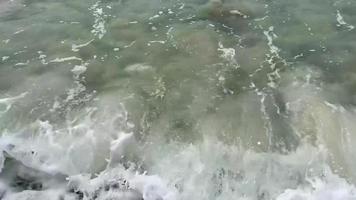 las olas bañan los adoquines de la playa video