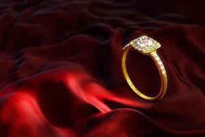 un anillo de oro y diamantes sobre terciopelo rojo. foto