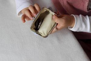 Kids hands put coins in a wallet,toddler girl with money and pusre in hand.Learning financial responsibility and planning savings.Financial education for child,financial support.Investing in children photo