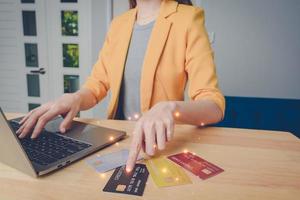 Business woman are choosing the best credit card. young girl shopping online, ordering, paying with many credit card, using laptop, makes secure payment online. internet bank service concept. photo
