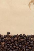 granos de café tostados, patrón de granos de café sobre fondo de papel manchado marrón.