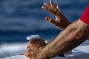 hands of sailor detail on ship bollard photo