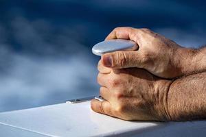 hands of sailor detail on ship bollard photo