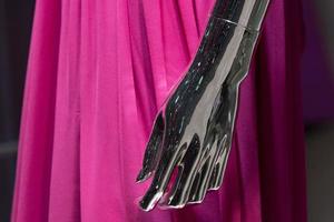 Silver woman mannequin hand detail with pink dress photo