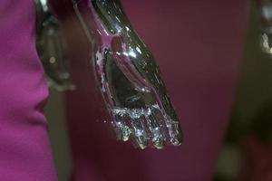 Silver woman mannequin hand detail with pink dress photo