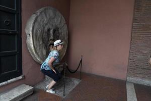 roma, italia - 15 de junio de 2019 - turista probando la máscara de la boca de la verdad foto