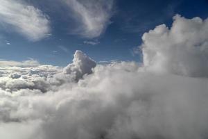 cloudy sky from airplane window while flying photo