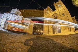 vista nocturna de la catedral de lisboa con tranvía foto