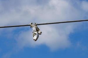 Woman female shoes hanging on wire cable photo