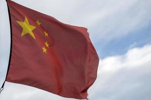 waving chinese flag red background and yellow stars photo
