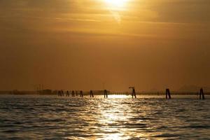 Sunset in Venice lagoon chioggia harbor from a boat photo