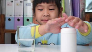 Cute little girl eating alpha omega 3 or Vitamin pill. Vitamin supplements for children for better immunity. video