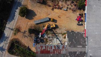 une grue mobile attend de soulever de l'acier dans un entrepôt. grutiers et grues mobiles travaillant sur un chantier de construction. video