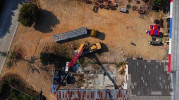 puestos de grúas móviles esperando para levantar acero en un almacén. operadores de grúas y grúas móviles que trabajan en un sitio de construcción. video