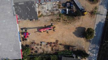 puestos de grúas móviles esperando para levantar acero en un almacén. operadores de grúas y grúas móviles que trabajan en un sitio de construcción. video