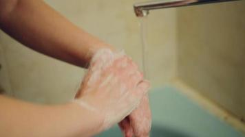 Woman washing her hands with soap in the bathroom video