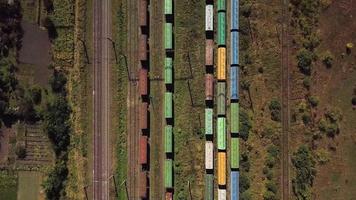 Flying above industrial railroad station with cargo trains