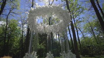 Wedding arch of white flowers in the park video