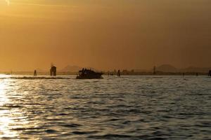 puesta de sol en el puerto de chioggia de la laguna de venecia desde un barco foto