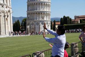 pisa, italia - 26 de septiembre de 2017 - turista tomando fotos en la famosa torre inclinada