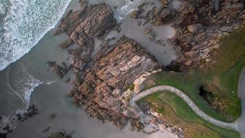 overhead visie van rotsachtig kustlijn, golven, en pad naar de strand video