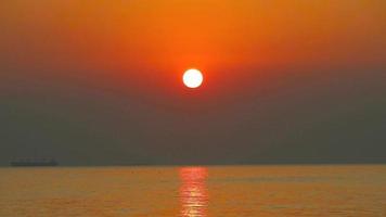 tramonto indietro su il buio nube su orizzonte mare e silhouette carico nave parcheggio video