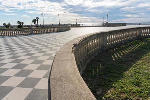 Livorno,Italy-november  27, 2022-people strolling on the Mascagni terrace, a splendid belvedere terrace with checkerboard paved surface, Livorno, Tuscany, Italy during a sunny day. photo