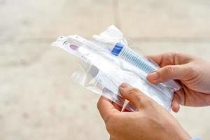 Close up to Asian man holds the Coronavirus Test Kit in his hand at outdoor field. photo