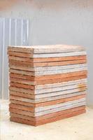 Brick foam board pile are arranged layer tower on sand floor at construction field.
