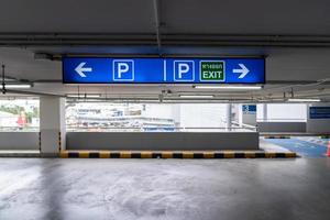 Signage Lightingbox in the indoor carparking, tell driver which way is parking lot or exit. Thai Language in green square on lightinbox means EXIT. photo