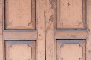 pared de madera de fondo clásico y puerta frente al edificio tradicional vintage de tailandia. foto