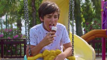 Teenage Boy Shows Ice Cream Towards Camera While Eating Ice Cream video