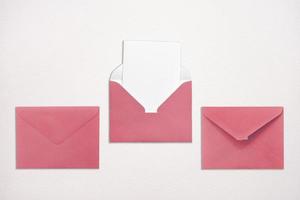 Three pink envelopes on white background one open with a note inside. Place for your text. Delivery service. photo