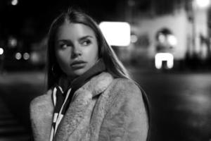 black and white portrait of a girl against the background of a night city photo