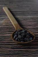 Melt chocolate buttons on a wooden spoon on a rustic background photo