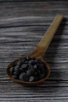 Melt chocolate buttons on a wooden spoon on a rustic background photo